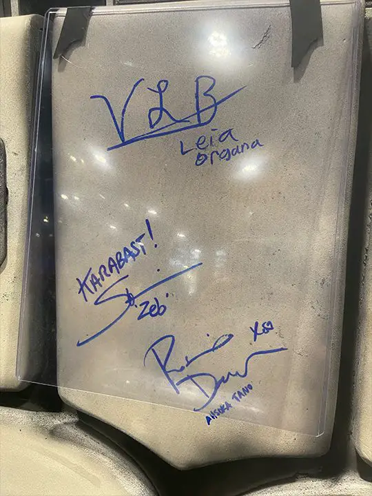 Rosario Dawson, Vivien Lyra Blair, and SW Rebels' Zeb Orrelios (Steve Blum) autographs on the Holochess area of the Millennium Falcon.