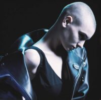 a picture of a bald woman in a leather jacket