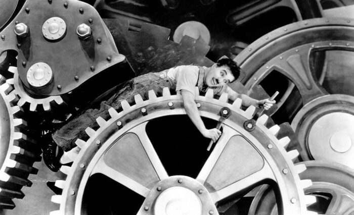A man is caught in the cogs of a giant machine