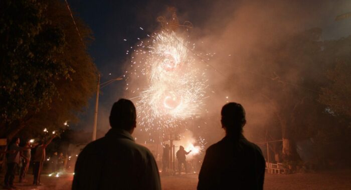 Two people watch fireworks.