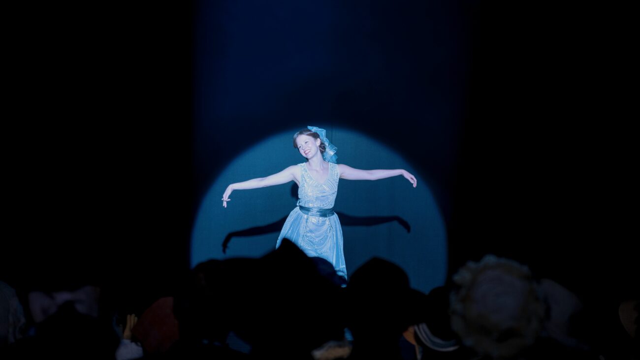 Pearl lit by a single spotlight on stage