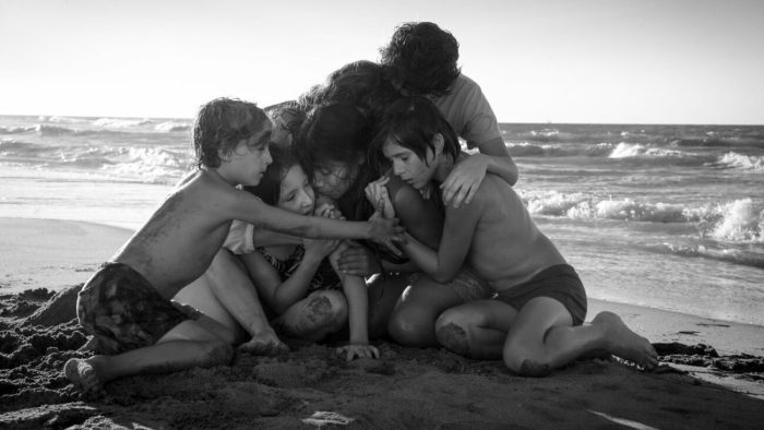 A family embraces on the beach.
