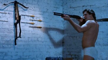 The hero standing in his underwear, aiming a shotgun.