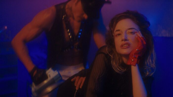 Karl Glusman and Andrea Riseborough in one of Suze's fantasies. Plenty of bisexual lighting and leather daddy imagery