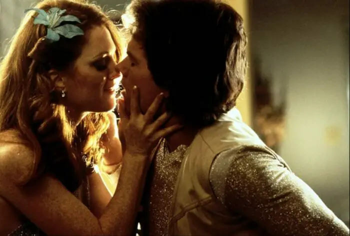 Wearing sparkly and gaudy '70s outfits fit for a pornographic scene, Amber (Moore) and Dirk nearly kiss while shooting.