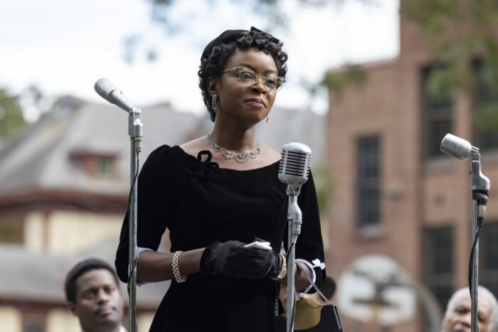 A woman in a black dress and glasses speaks at a microphone in "Till"