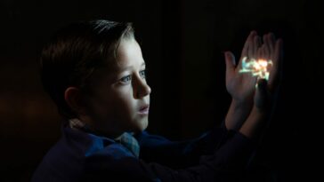 Mateo Zoryan Francis-DeFord as younger Sammy Fabelman gazes at a projected image in The Fabelmans