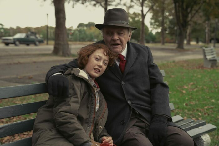 An older gentleman hugs a teenager on a park bench in "Armageddon Time."