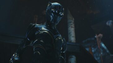 A woman in an armored suit stands ready for battle in Black Panther: Wakanda Forever