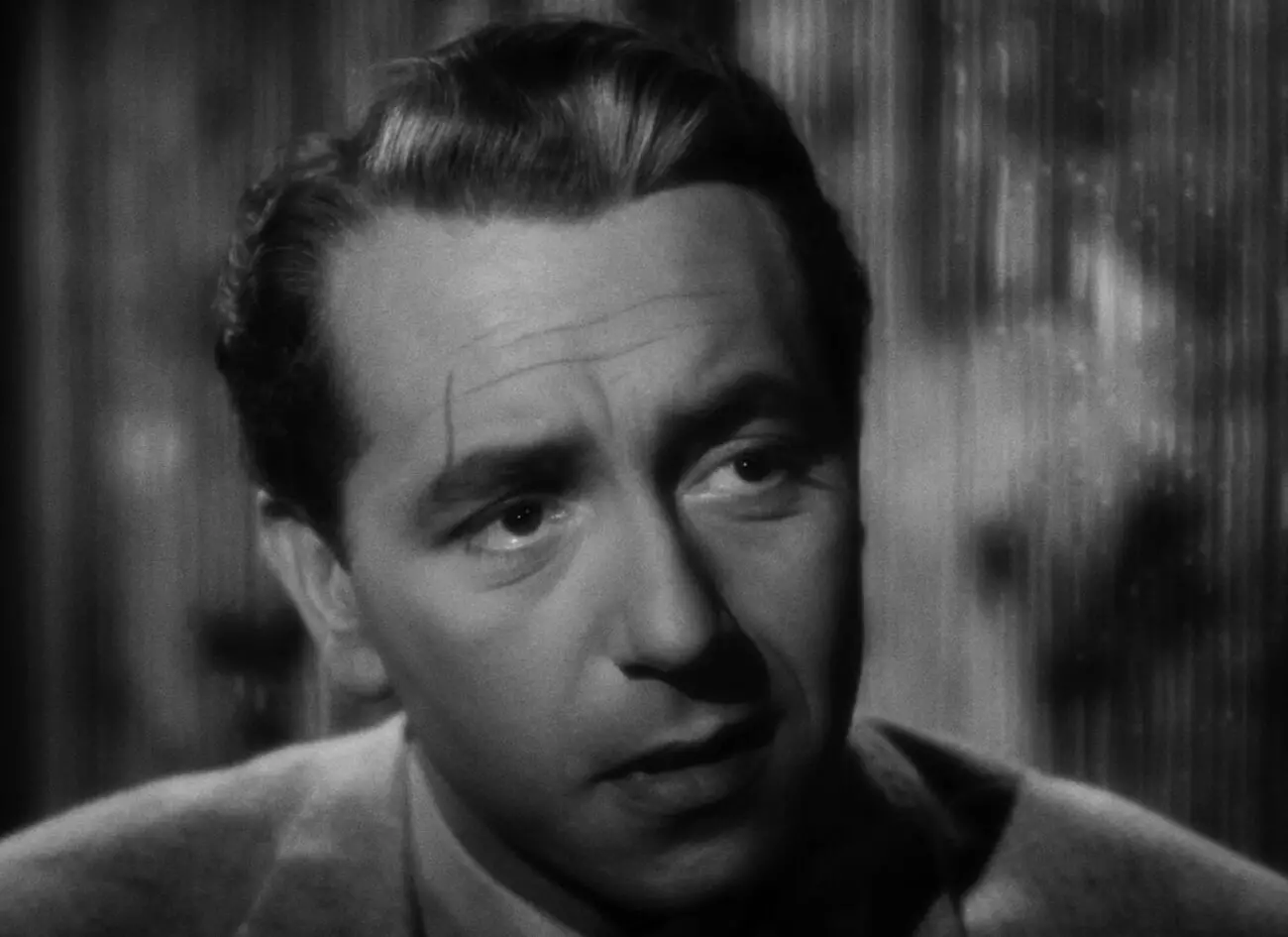 A man with a slightly scarred face discusses politics in Casablanca