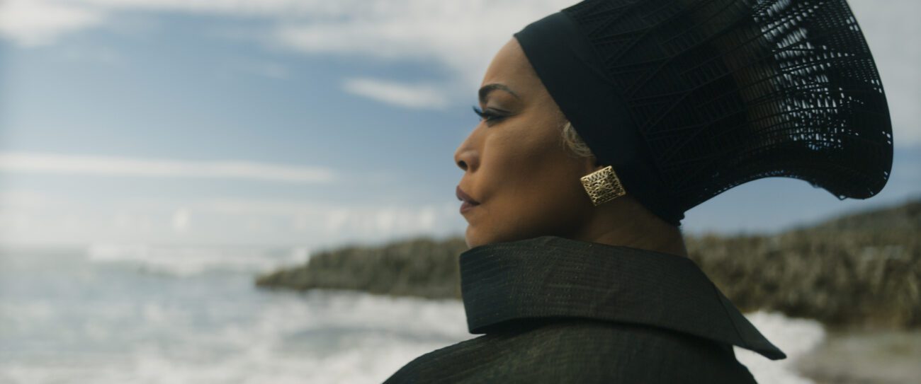 A woman in a headdress stands on a beach in Black Panther: Wakanda Forever
