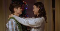 Sam and Becca embrace as they decorate the Christmas tree