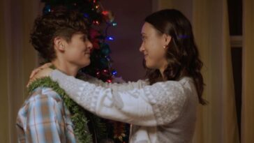 Sam and Becca embrace as they decorate the Christmas tree