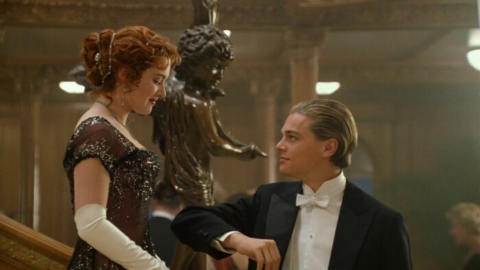 A man offers his arm to a woman in Titanic