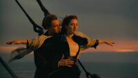 A man holds a woman with arms extended on the front of an ocean liner in Titanic