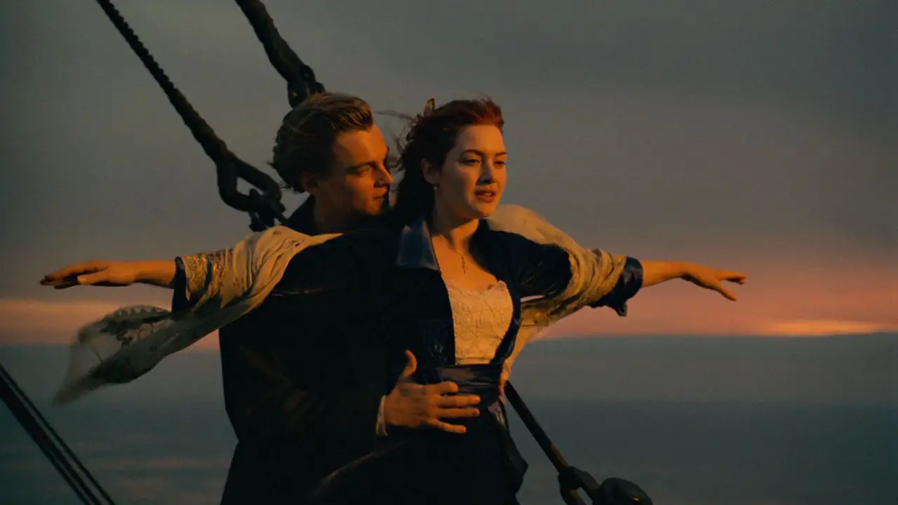 A man holds a woman with arms extended on the front of an ocean liner in Titanic