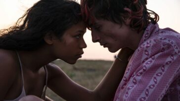 Taylor Russell (left) as Maren and Timothée Chalamet (right) as Lee touching foreheads, intimatly, on a hillside