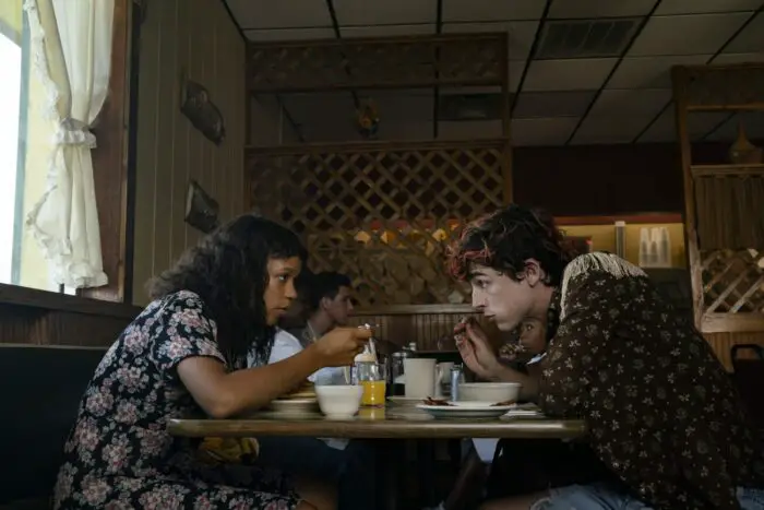 Taylor Russell (left) as Maren and Timothée Chalamet (right) as Lee at a diner eating breakfast