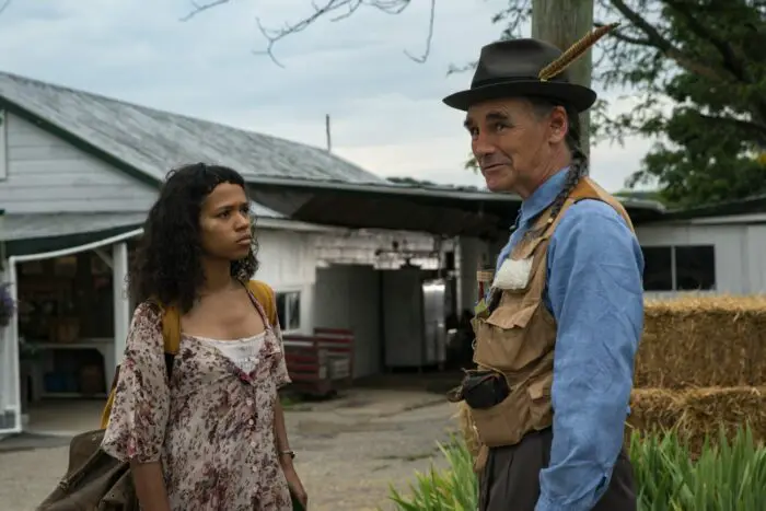 Taylor Russell as Maren and Mark Rylance as Sully standing by a market talking after sully confesses he's been following her