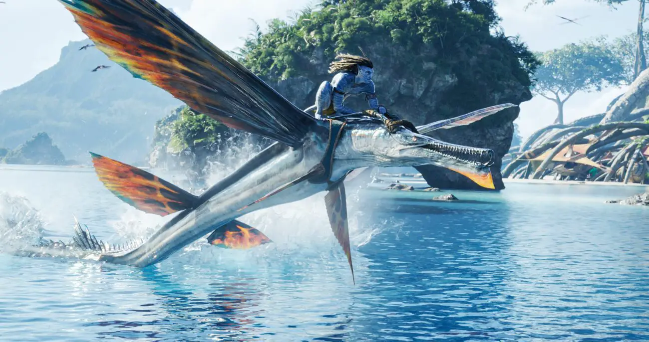 An alien man flies a winged beast over water in Avatar: The Way of Water