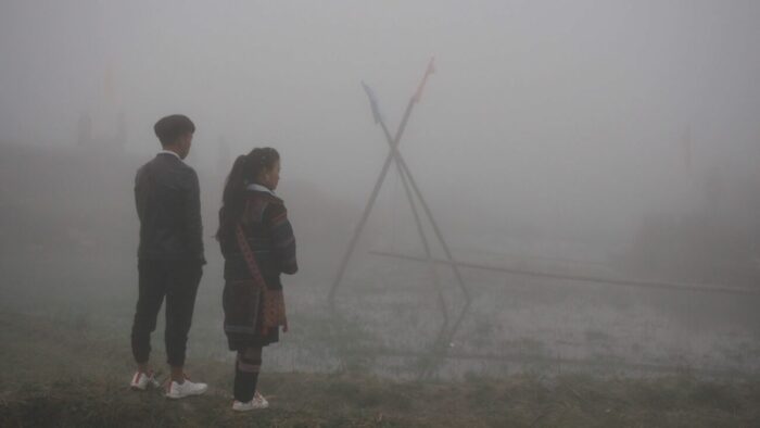 Di and her prospective husband stand in the misty fog.