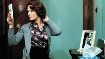 Image from Jeanne Dielman: The protagonist checks her makeup in a hand mirror.