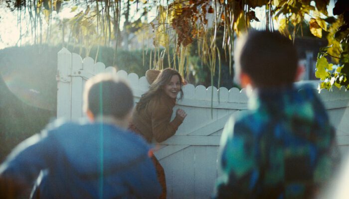 Julie smiles at her two children as she closes a gate.