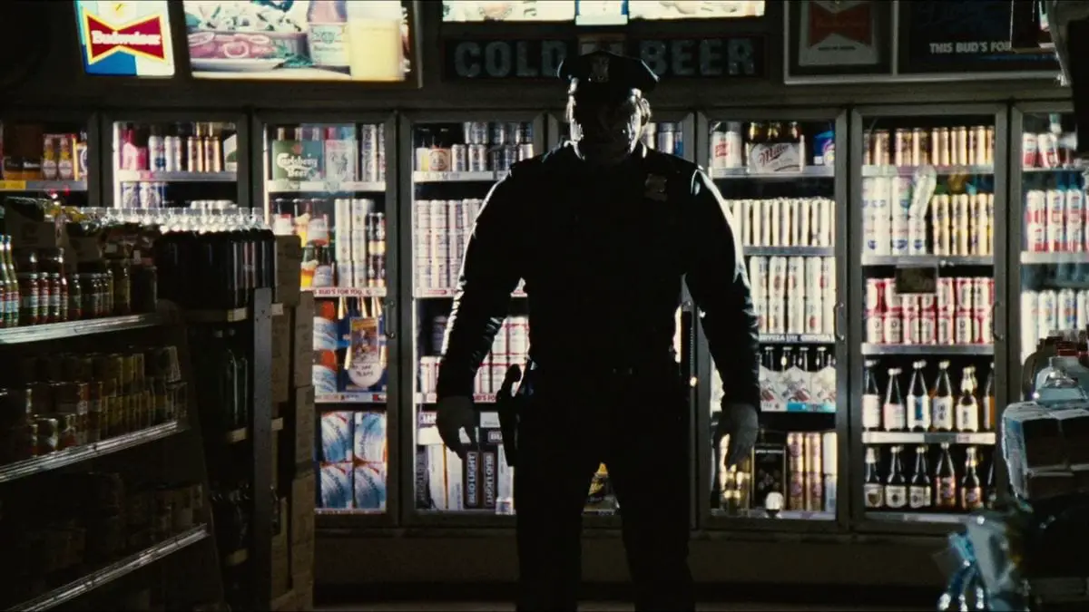 The Maniac Cop stands in silhouette inside a convenience store