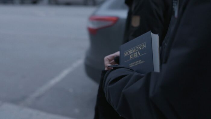 A person in a parka carries a bible.