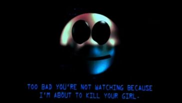 On a computer monitor, a smiling face with the text saying, "Too bad you're not watching because I'm about to kill your girl."