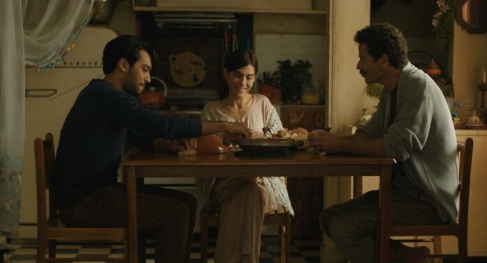 From left: Ayoub Missioui as Youssef, Lubna Azabal as Mina, and Saleh Bakri as Halim sit down to a meal in The Blue Caftan.