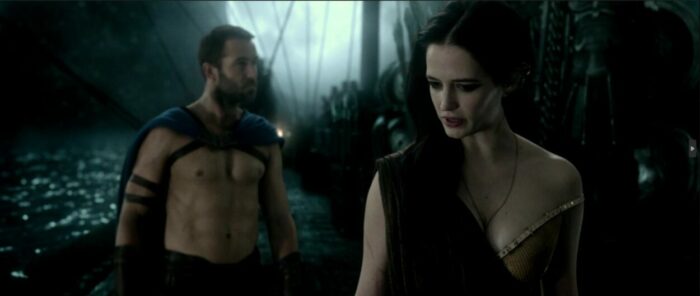 General Themistocles follows Artemisia as they walk on the deck of a ship with the ocean behind them in 300: Rise of an Empire