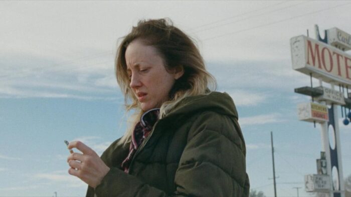 Andrea Riseborough as Leslie stands in the cold, wearing a parka
