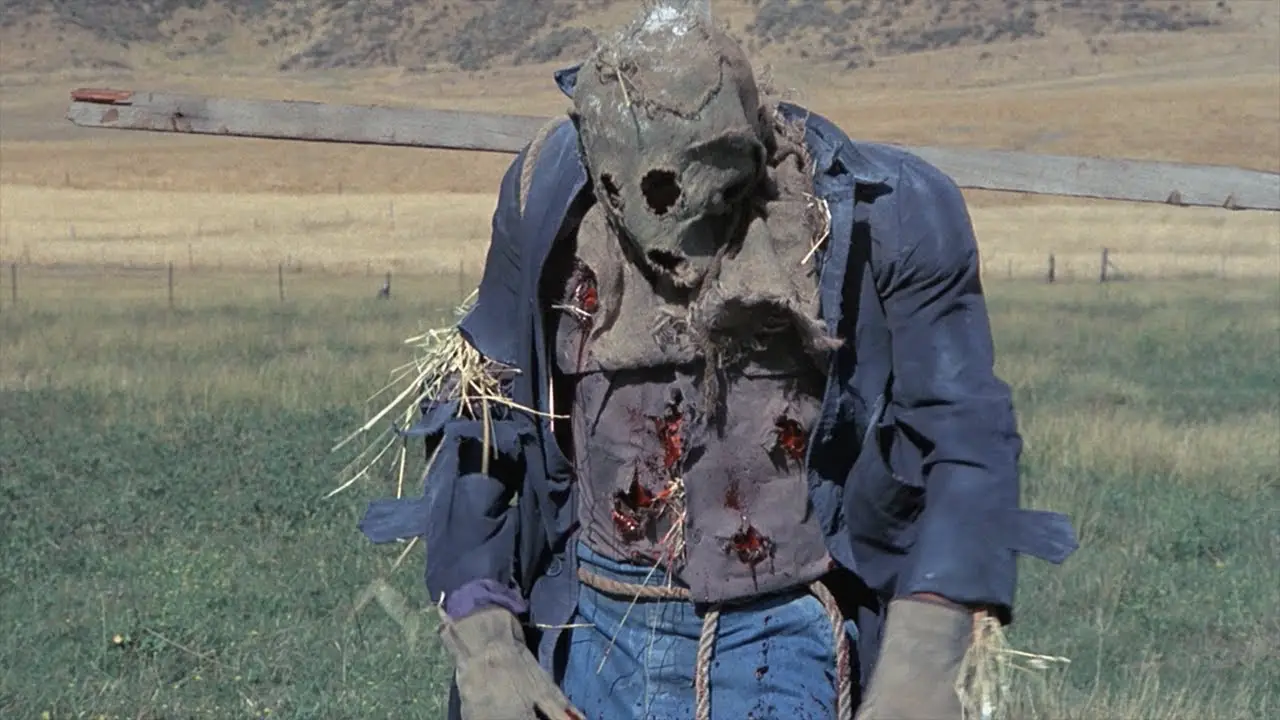 The Scarecrow is slumped on a post with bullet wounds in its chest.