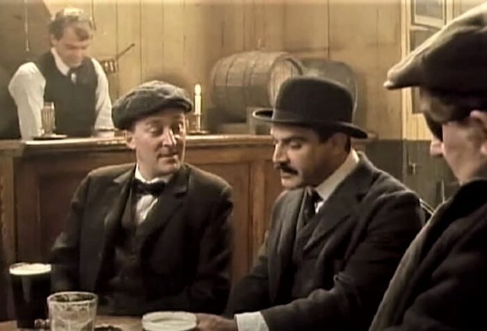 Men in a bar drinking pints of dark beer. All wearing suits. Based on a scene in Ulysses by James Joyce