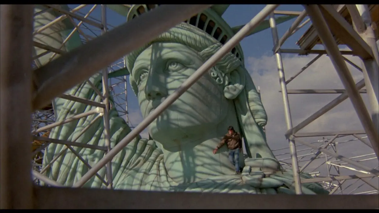 A man runs down the Statue of Liberty, which is under construction.