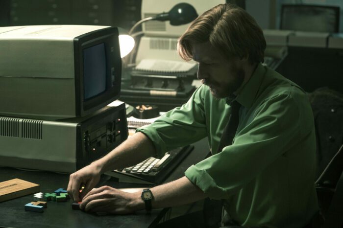 A man adjusts hardware on a computer.