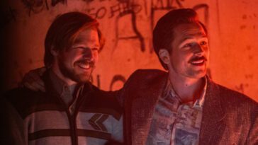 Two men smile at an underground night club in Tetris.
