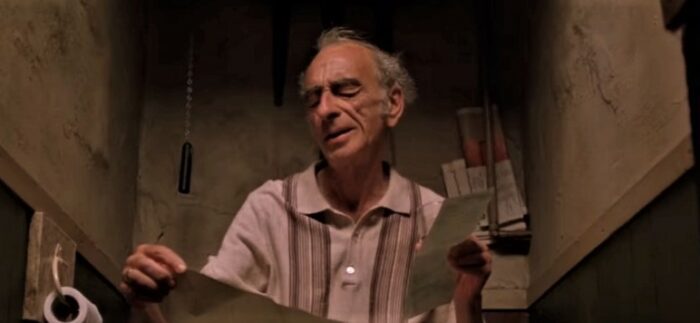 David Kelly as Michael O'Sullivan in Waking Ned Devine, feigning stomach troubles so he can read info he can't remember while hiding in the bathroom.