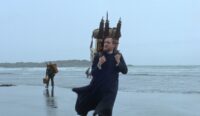 Elliott Crosset Hove as Lucas crosses a wet beach in Godland.