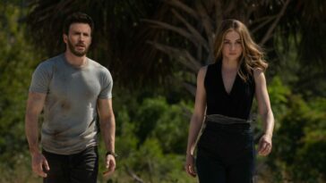 Chris Evans and Ana de Armas in Ghosted walking on a beach towards the camera looking worse for wear