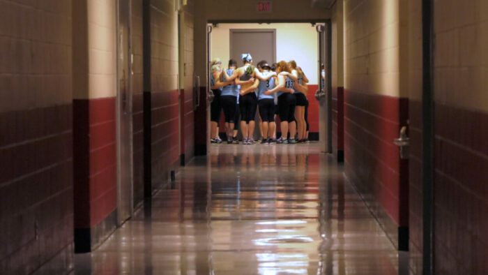 Members of the team huddle in a hallway.