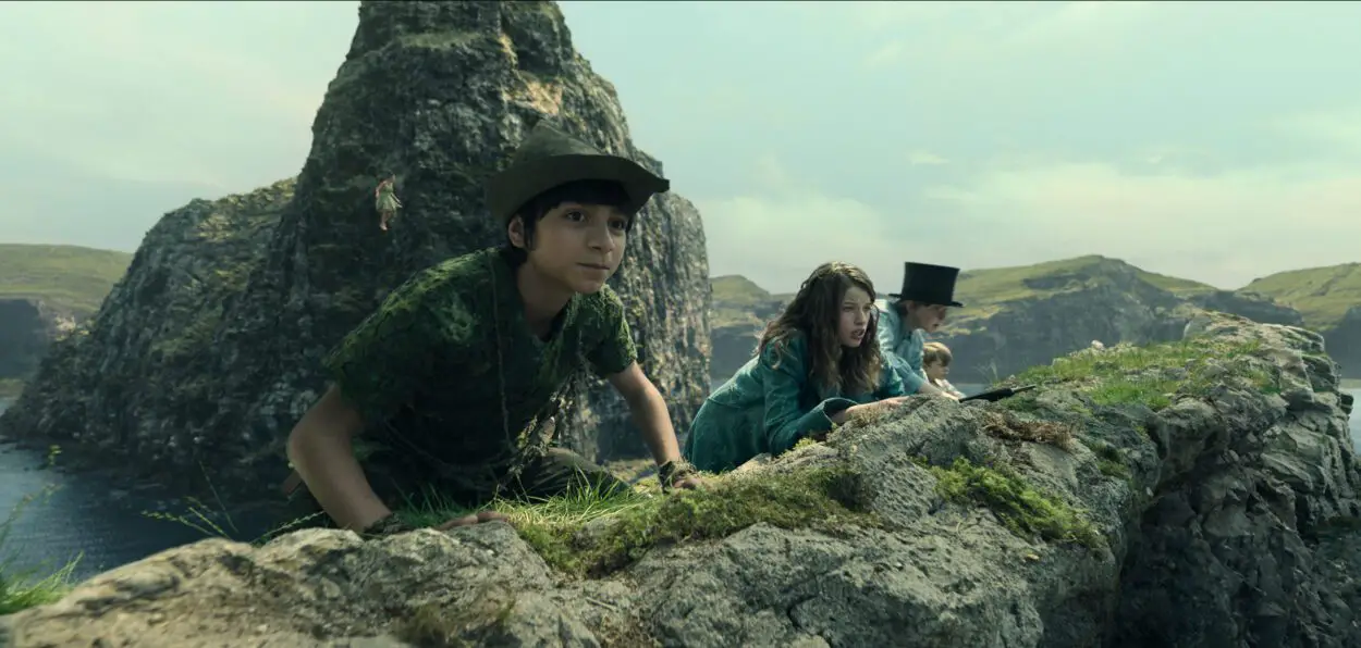 A group of children peer over a hill towards their pursuers in Peter Pan & Wendy.