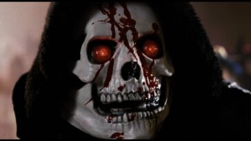 A white skeleton mask with red eyes has blood on the face.