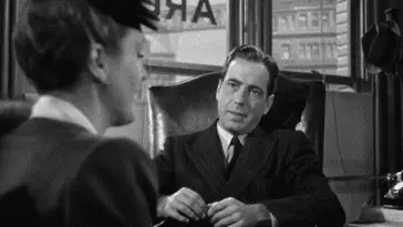 Sam Spade sits at his desk and listens to a new client tell her story.
