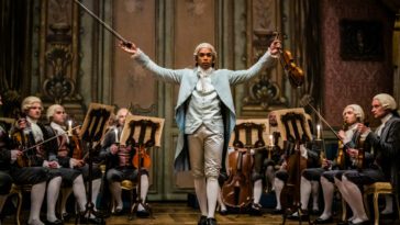Kelvin Harrison Jr. in the film CHEVALIER, standing before an orchestra about to conduct. Photo by Larry Horricks. Courtesy of Searchlight Pictures. © 2022 20th Century Studios All Rights Reserved.