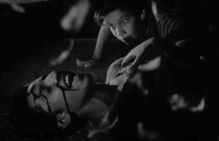 dream scene from los olvidados, depicting a young boy gasping in shock at a bleeding man