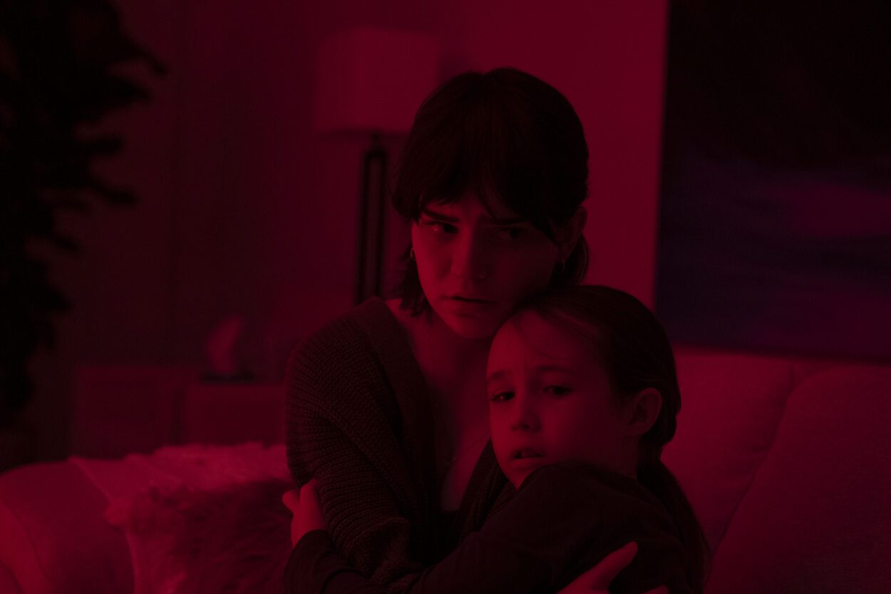 (L-R): Sophie Thatcher as Sadie Harper and Vivien Lyra Blair as Sawyer Harper in 20th Century Studios' THE BOOGEYMAN. Two young ladies clutching one another in terror, bathed in red light. Photo by Patti Perret. © 2023 20th Century Studios. All Rights Reserved.