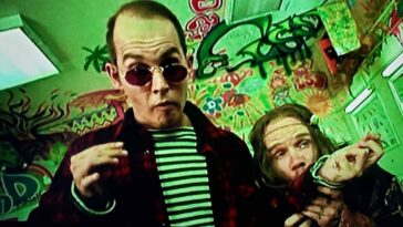 Flea and Johnny Depp as Raoul Duke and the hippie licking LSD off his sleeve in Fear and Loathing in Las Vegas (1998).