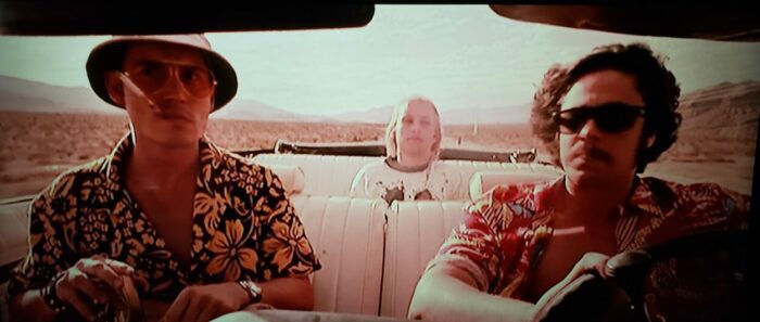 Johnny Deppas Raoul Duke seated at a typewriter writing in Fear and Loathing in Las Vegas.